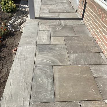 Front porch finished in hand-laid natural stone; a premium exterior upgrade with lasting value.