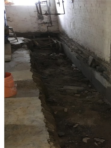 Excavation and structural reinforcement during underpinning of century home.