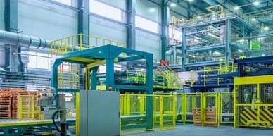 Modern industrial factory interior with machinery and safety barriers.