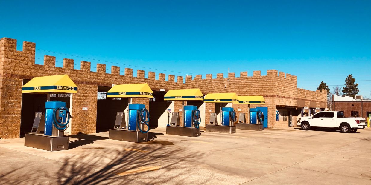 Empty car wash vacuum stations with yellow canopies.