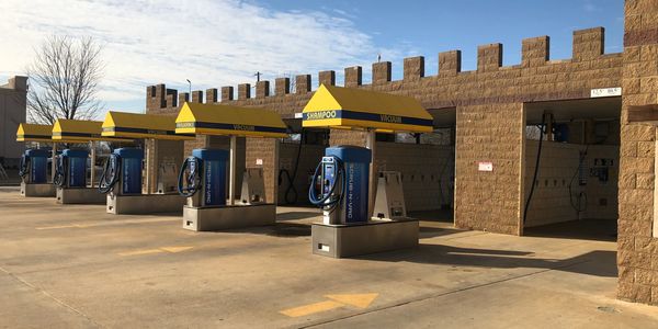 Empty self-service car wash with several bays and shampoo stations.