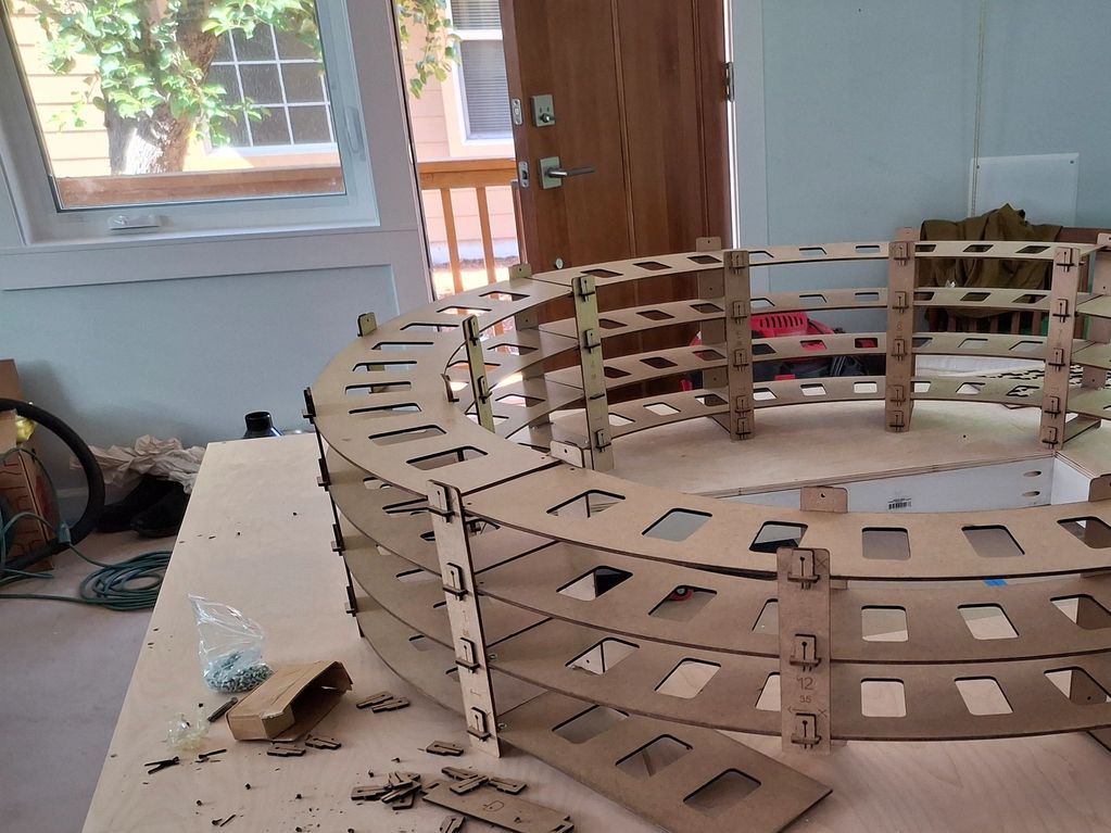 Wooden circular structure under assembly on a table.