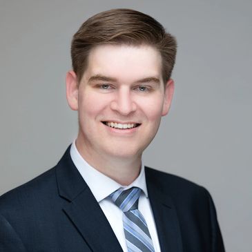 Profile image of Dr. Jordan Galpin, wearing full suit attire and smiling confidently.