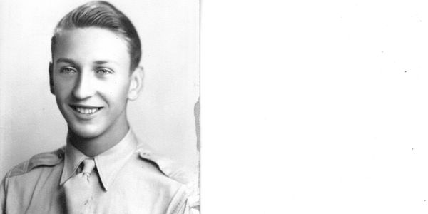 Young man in military uniform smiling.