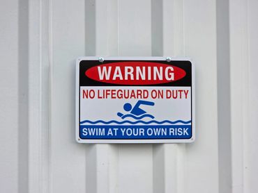 Lifeguard on duty safety sign near the pool area at Life’s a Beach Uvita