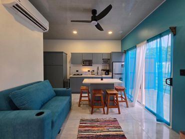 Living room area with comfortable seating, natural light, and wooden accents”