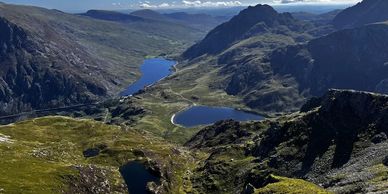 Panoramic view of mountain valleys with lakes under a clear blue sky near the Dyfi valley