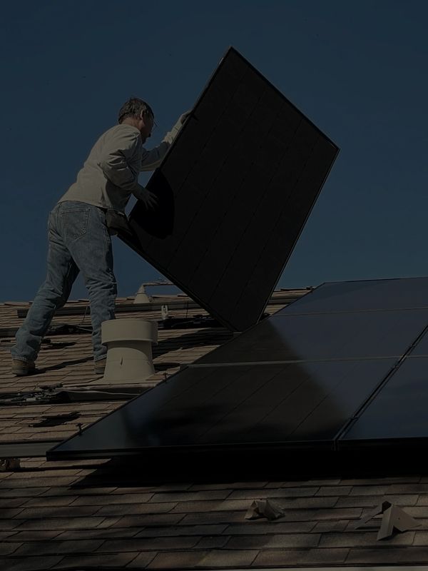 Solar installer working with Palmetto Energy Solutions installing a black solar panel on a rooftop