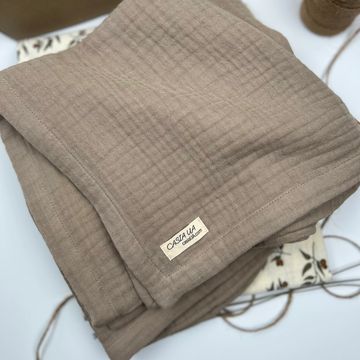 Soft brown textured fabric folded neatly with a Casa Ua label.
