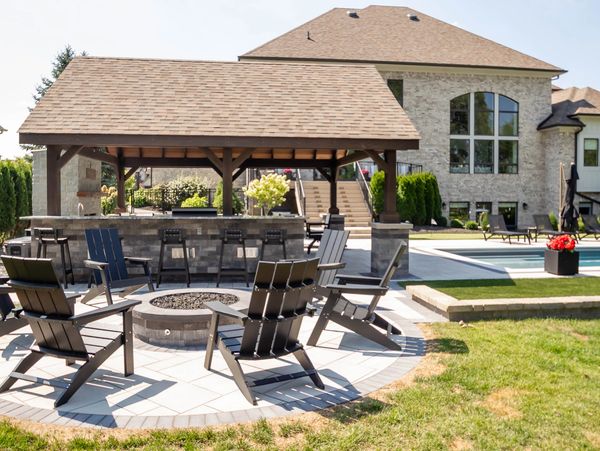 Backyard patio with Adirondack chairs and a covered bar area.