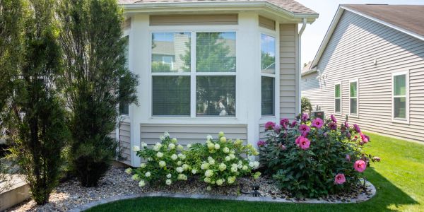 House with bay window and garden with flowers.