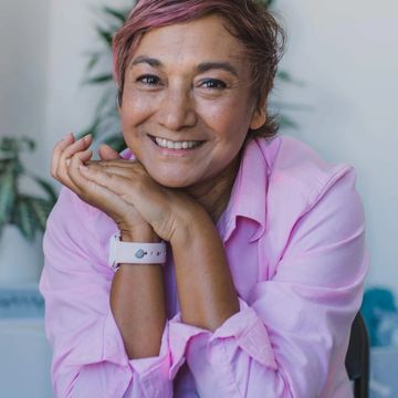 A picture of Ms. Charmaine Thane, wearing a pink button down and smiling