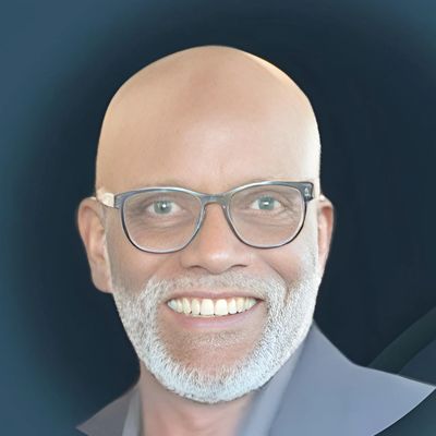 Smiling man with glasses and a white beard.
