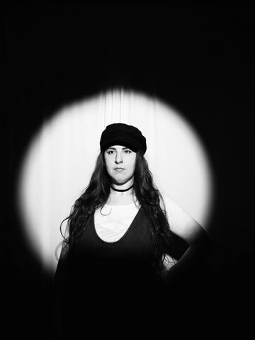 Black and white portrait of a woman under spotlight.