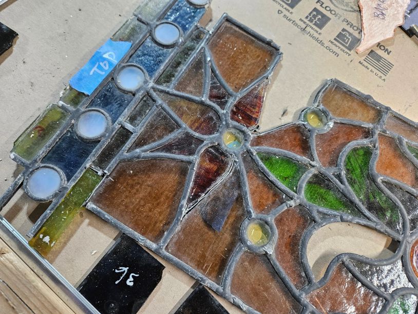 Close-up of stained glass pieces on cardboard.