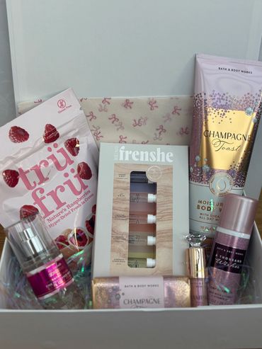 A gift box with skincare, fragrance samples, and dried raspberries.