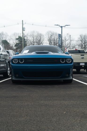 Front view of a blue Dodge Challenger in a parking lot.
