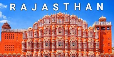 The pink sandstone facade of Hawa Mahal in Rajasthan under a clear blue sky.