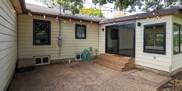 Cozy backyard patio with string lights and wooden steps.