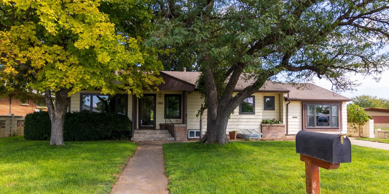 Suburban house with green lawn and mailbox.