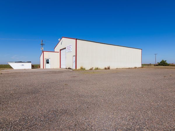 A white industrial building under a clear blue sky.