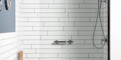 Bathtub converted to walk in shower with subway tile pattern wall surround and folding shower seat.