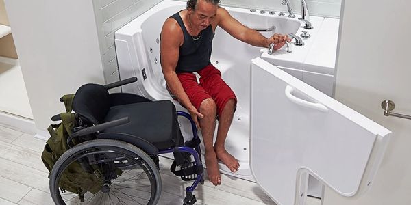 Transferring from wheelchair to walk in bathtub installed by Mobility Bath Systems.