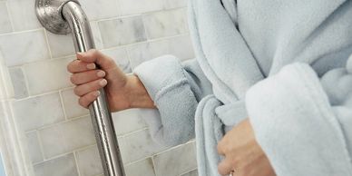 Wall mounted safety grab bar installed for elderly shower safety at home by Mobility Bath Systems.