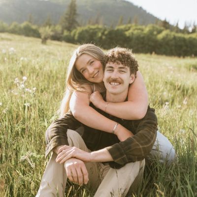 Couple embracing in a sunny field.