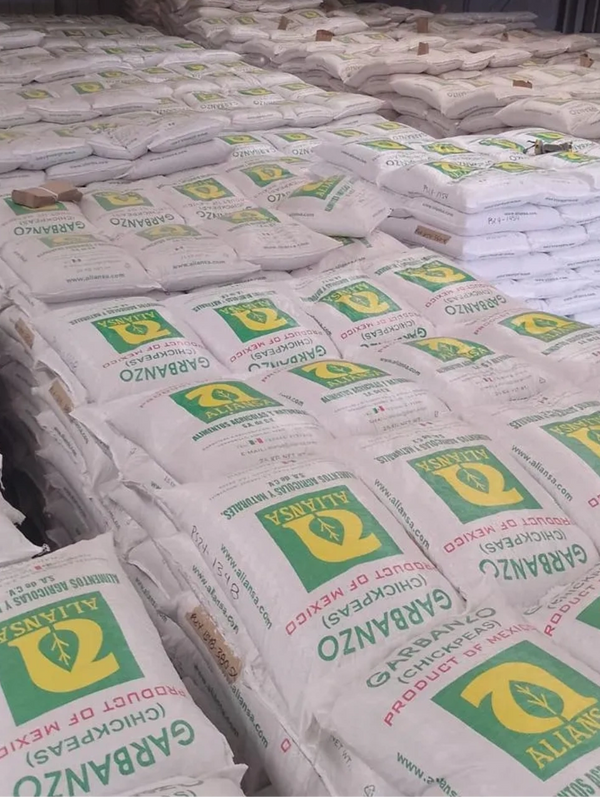 Stacks of white sacks labeled Garbanzo chickpeas, product of Mexico.