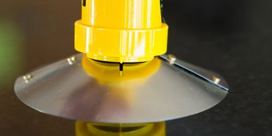 Yellow UCO Candle Lantern with yellow Survival Stand links to Pak Flat Reflector on shiny table