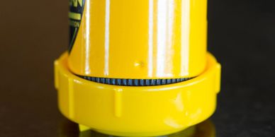 UCO Candle Lantern being inserted into Survival Stand on reflective table