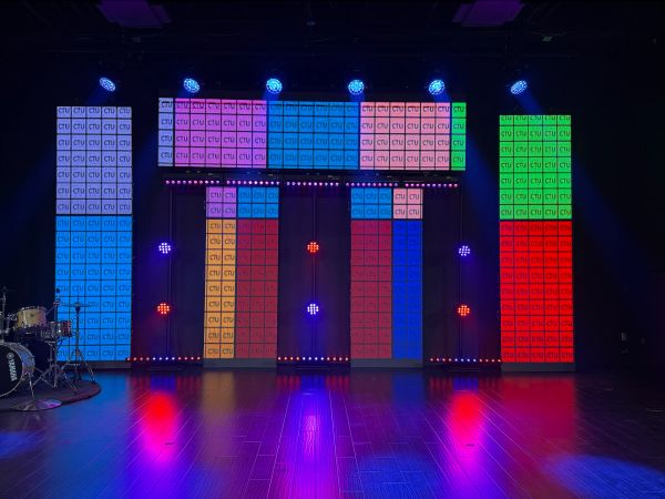 Colorful light panels spelling CTU on a stage with drum set.