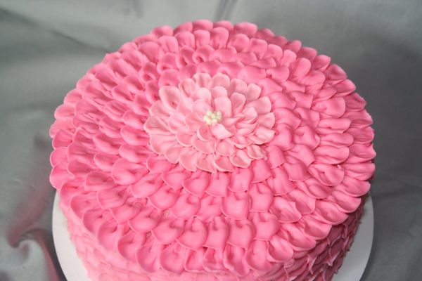 Pink flower-themed cake with intricate petal design.