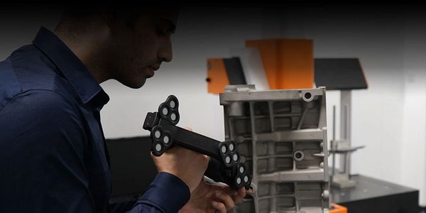Hombre usando herramienta para escanear objeto industrial.