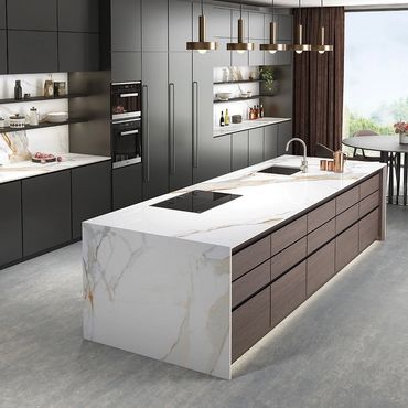 Modern kitchen with marble countertops and sleek dark cabinets.