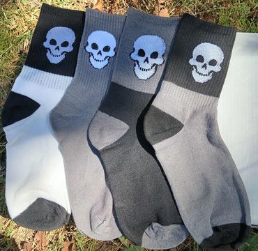 Four pairs of socks with skull designs in various gray and black shades.