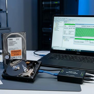 Forensic data recovery setup with hard drives and laptop.