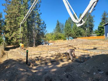 Workers preparing concrete foundation at a construction site.