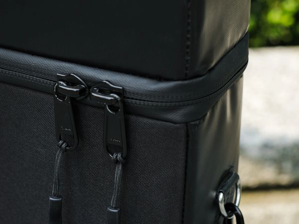 Close-up of black bag zippers and fabric.