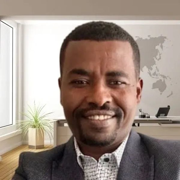 Man smiling in a modern office with world map on the wall.