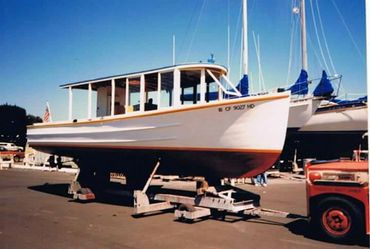 A white boat on supports in a marina with clear sky.
