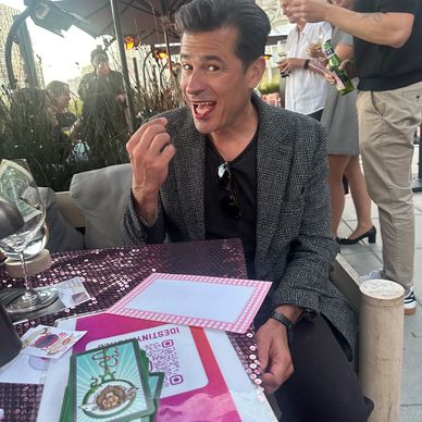 Man enjoying a cigarette at a table outdoors.