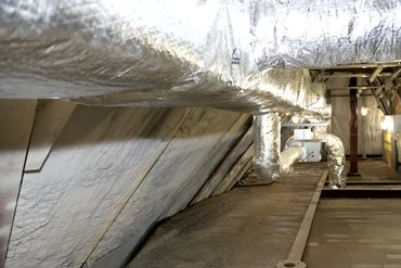 Insulated HVAC ductwork running along an attic space.