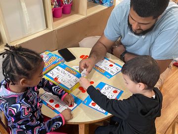 Preschool room playing letter bingo with a letter recognition game.