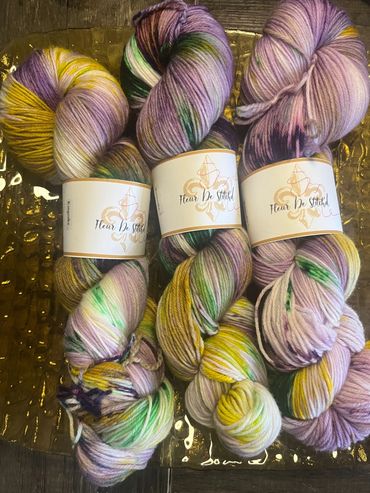 Three skeins of multicolored hand-dyed yarn from Fleur De Stitched.
