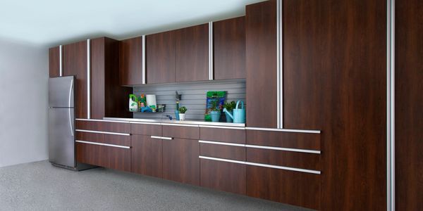Coco Finished Garage Cabinets with Extruded Handles and a stainless steel workbench.