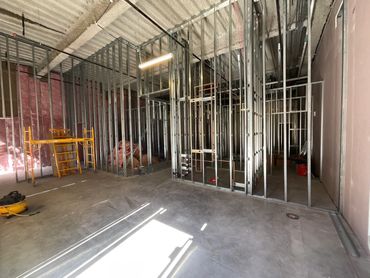 Interior view of a building under construction with metal framing and insulation.