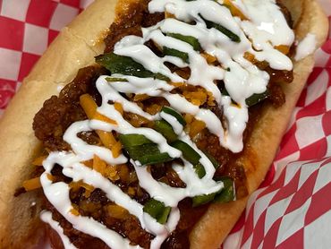 Pearl’s Supreme Chili Dog topped with chili, jalapeños, shredded cheddar, and sour cream.