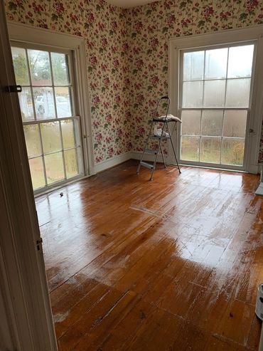 The upstairs front room and its near full-length heart pine flooring after an initial cleaning.